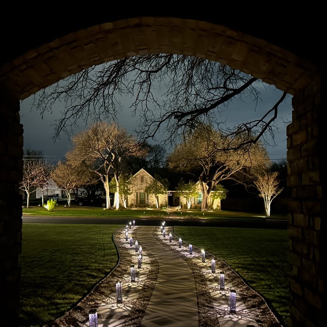 Residential walkway with decorative path lights and architectural lighting at night